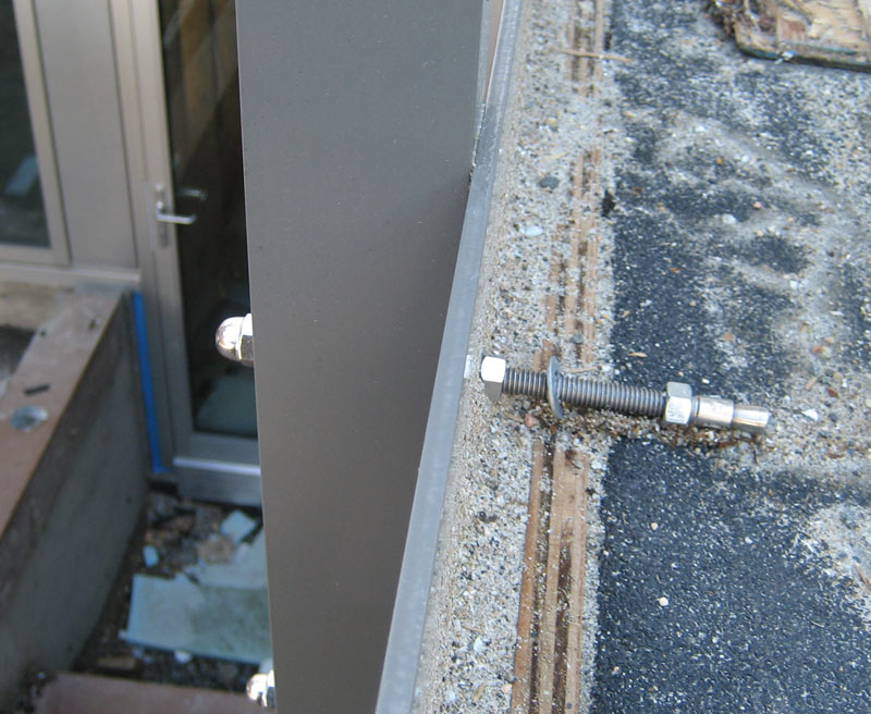 ALUMINUM-STANCHIONS-ATTACHED-TO-CONCRETE-WALL-THROUGH-A-PAINTED-METAL-FASCIA-PLATE-BEFORE-GLASS-GUARD-INSTALLATION3