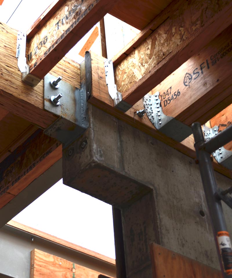 DETAIL---complex-connection-between-concrete-and-wood-beams,-with--steel-saddle-welded-to-embedded-steel-baseplate